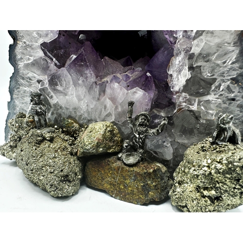 409 - An amethyst and pyrite geode with applied fools gold mining figures, 26cm high x 16cm wide