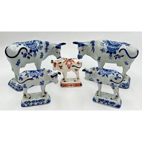 2192 - Two graduated pairs of Delft blue and white porcelain cows with a further Imari pattern example, the... 