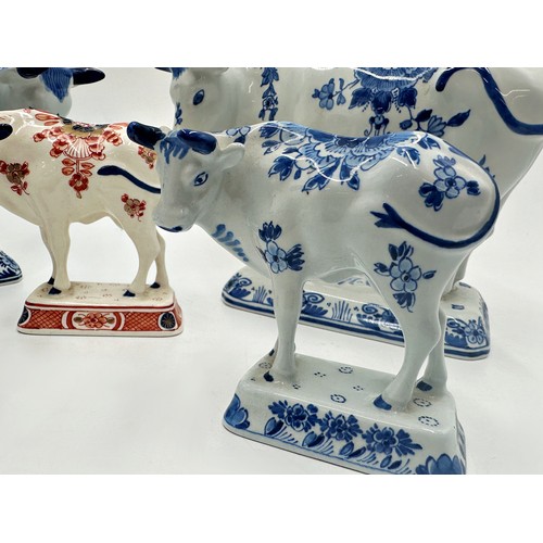 2192 - Two graduated pairs of Delft blue and white porcelain cows with a further Imari pattern example, the... 