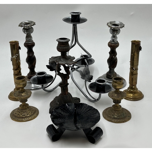 Large collection of wooden and brass candlesticks to include