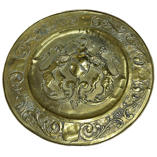 2400 - Large Arts and Crafts brass charger, embossed with coat of arms and scrolled acanthus boarders, 69cm... 