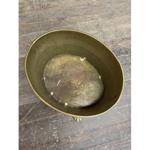 2383 - Antique brass paw footed and twin lion head handled coal or log bucket. W 42cm x H 30cm.