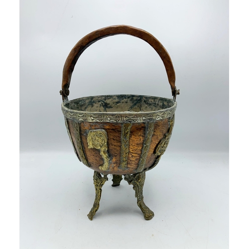 2384 - Copper and brass four footed Moroccan bowl with handle. H 38cm.