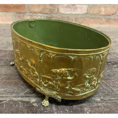 2386 - Brass coal or log bucket with four footed paw and cherub relief design. W 38cm x H 16cm.