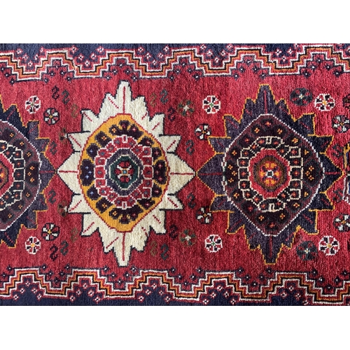 1431 - Persian thick pile Qashgai rug, three medallions on red ground, 170 x 75cm