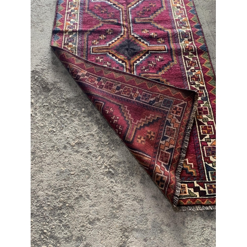 1435 - Good quality Persian Lori rug, bespoke medallion design on purple ground, 270 x 130cm