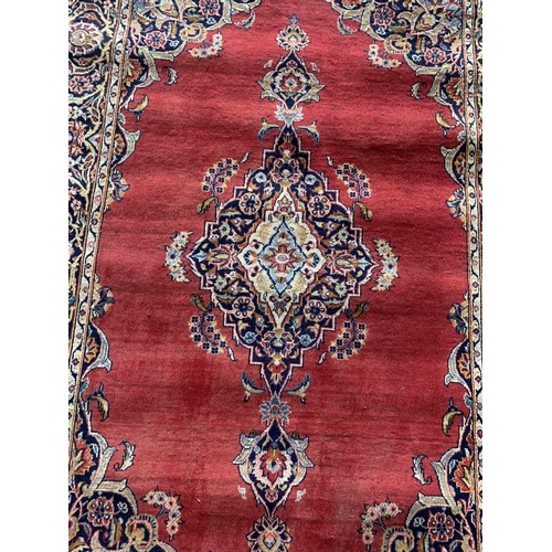 1443 - Traditional Persian Kashan rug, central blue medallion on red ground, 220 x 130cm