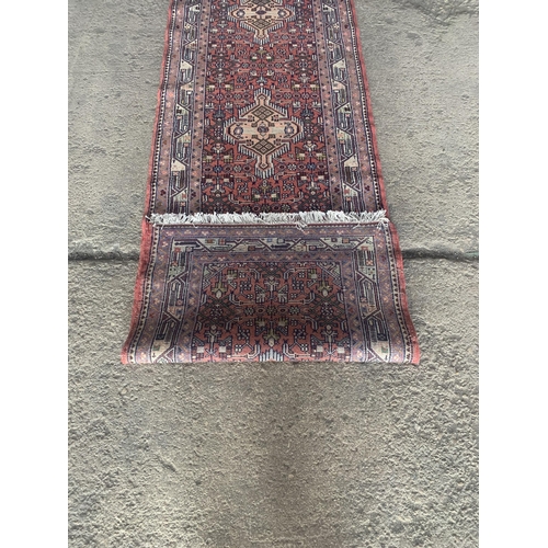 1445 - Good Persian Malayer runner, intricate three medallion design on washed red ground, 285 x 90cm