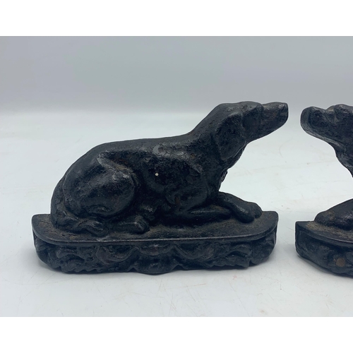 2395 - Pair of small cast iron door stops in the form of recumbent hounds, H 10cm