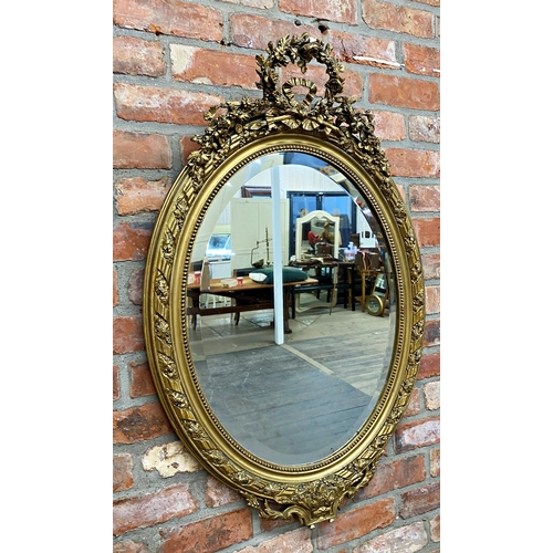 1057 - Late 19th century continental gilt wood and gesso oval wall mirror, mounted by plaster work wreath a... 