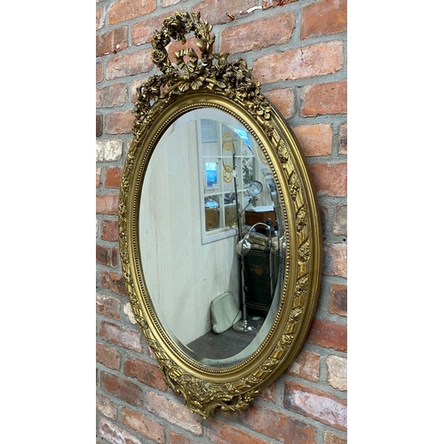 1057 - Late 19th century continental gilt wood and gesso oval wall mirror, mounted by plaster work wreath a... 