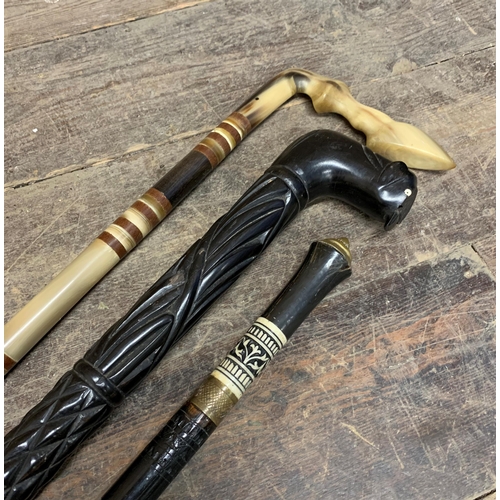 2316 - Three antique eastern walking sticks - ebonised sword stick, ebony elephant stick and horn specimen ... 