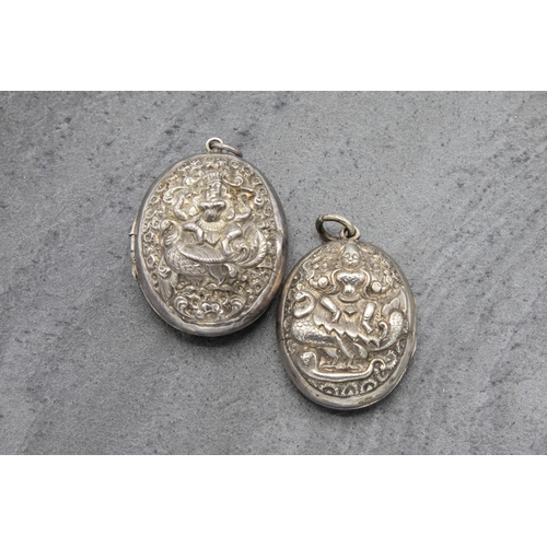 94 - Two similar Anglo-Indian silver locket pendants, each decorated in relief by a seated deity, the lar... 