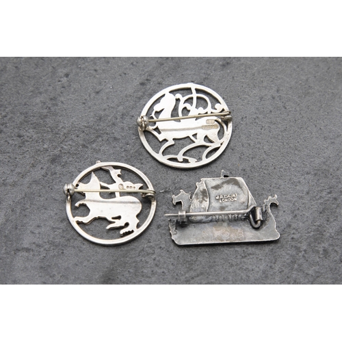 134 - Two Scottish Ortak Maeshowe Dragon silver brooches, with a further Shetland longboat silver brooch (... 