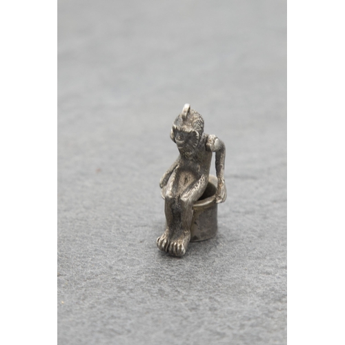 136 - Novelty silver cigar cutter charm in the form of a seated monkey, 3.5cm high