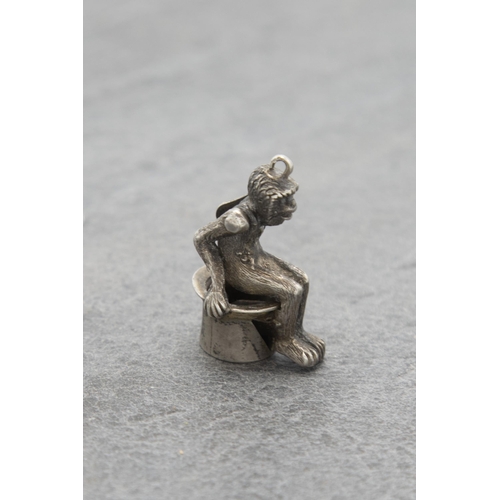 136 - Novelty silver cigar cutter charm in the form of a seated monkey, 3.5cm high