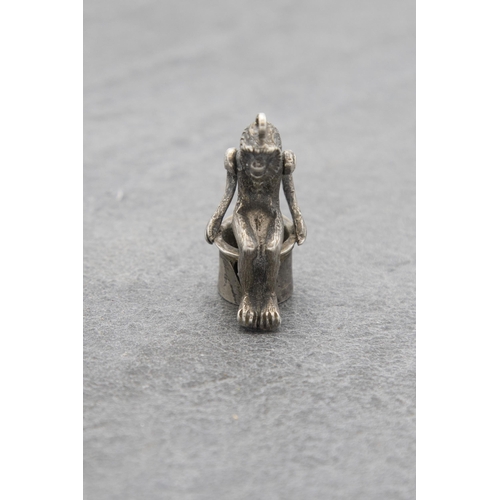 136 - Novelty silver cigar cutter charm in the form of a seated monkey, 3.5cm high