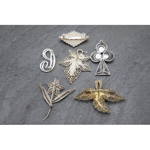 137 - Six filigree silver brooches or pendants to include turquoise inset club pendant and enamelled leaf ... 