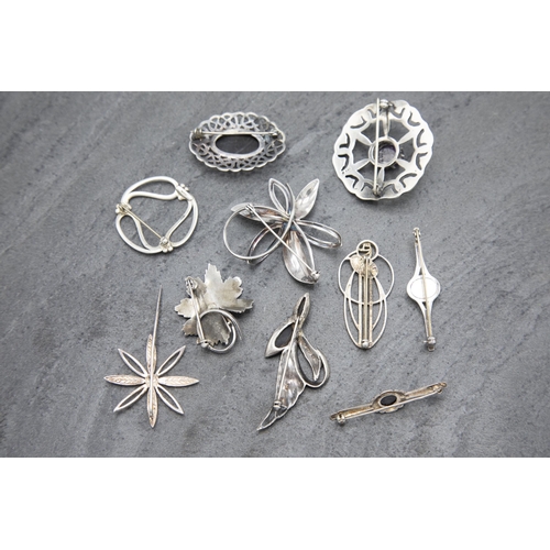 149 - Ten silver brooches to include Scottish examples, 73.6g, within Morocco leather case