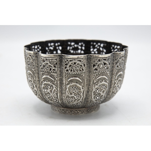 195 - Indian white metal (untested) lobed pedestal bowl embossed with scroll foliage, 11cm diameter, 6oz