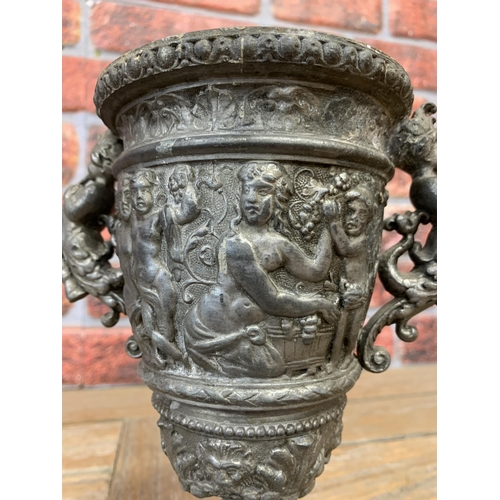 2225 - Pewter twin handled chalice, embossed with Bacchus bands and twin cornucopia mermaid handles, 23cm h... 