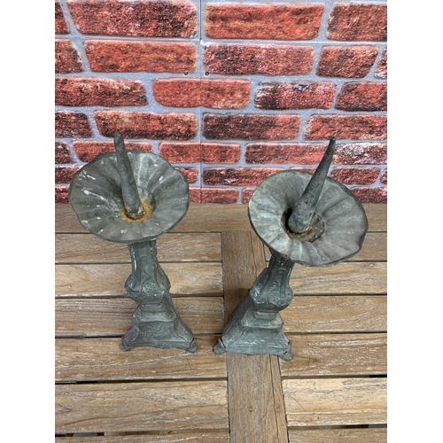 2231 - Pair of antique patinated sheet metal pricket sticks on embossed tri form columns, 63cm high (2)