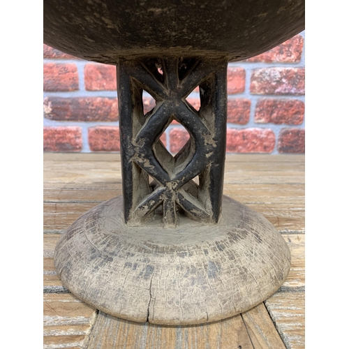 2102 - Vintage Tongan tribal stool with dished seat upon twin geometric pierced columns, 24cm high x 28cm d... 