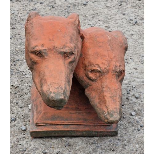 1010 - Composite terracotta study of two greyhound heads upon a stepped square base, 46cm long