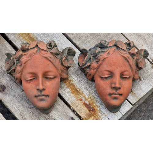 1017 - Pair of composite terracotta maiden heads with with floral headdresses, each 15cm x 15cm