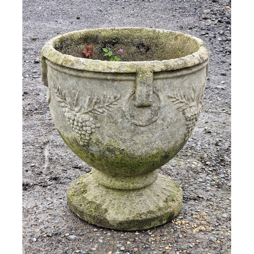 1057 - A weathered reconstituted stone garden urn with grape and ring relief, H 50cm x W 45cm