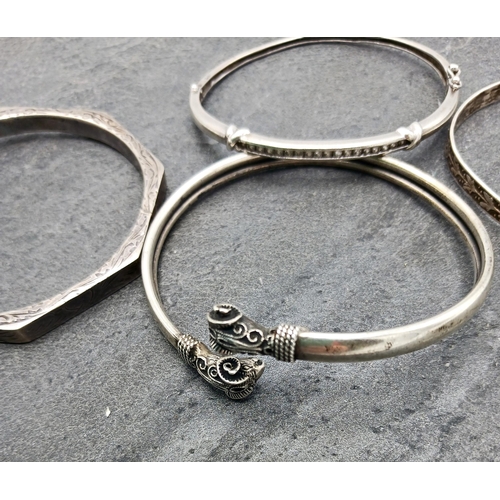 42 - Four silver bangles, two being hinged another with rams head details, 43.2g