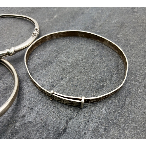 42 - Four silver bangles, two being hinged another with rams head details, 43.2g