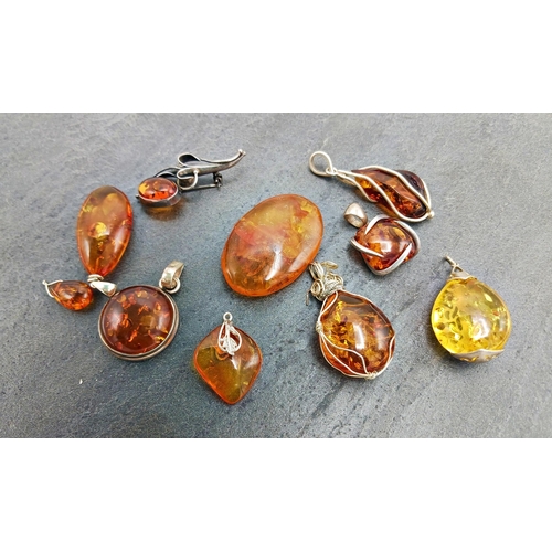 44 - Collection of eight amber and silver pendants, with a further silver and amber brooch and amber bead... 