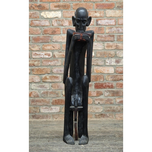 2096 - African carved wooden tribal figure of a seated nude man drinking, H 124cm x W 26cm