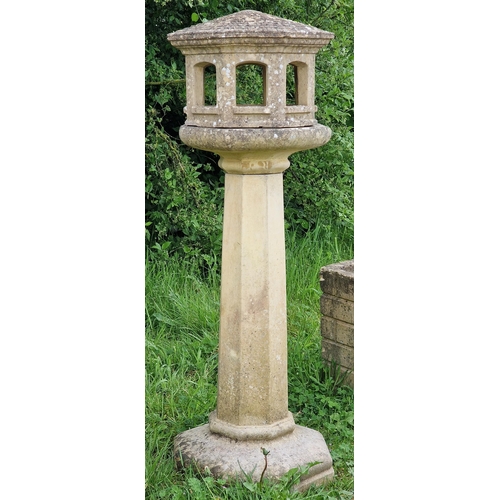 1044 - A three sectional weathered reconstituted stone garden bird table of octagonal form with simulated t... 