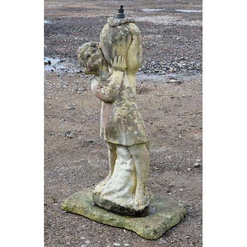 1050 - Weathered reconstituted stone water feature of a girl holding an urn raised on a square base, H 80cm