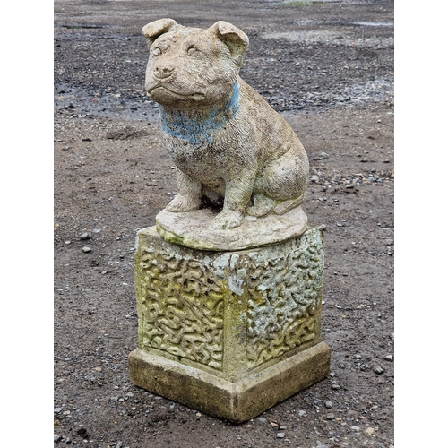 1053 - Weathered reconstituted stone statue of a dog raised on a square plinth, H 65cm