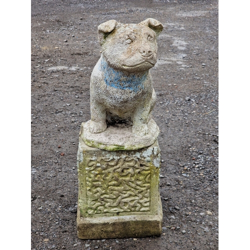 1053 - Weathered reconstituted stone statue of a dog raised on a square plinth, H 65cm