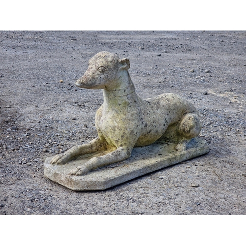 1074 - Reconstituted stone statue in the form of a recumbent greyhound, H 38cm x W 68cm x D 24cm