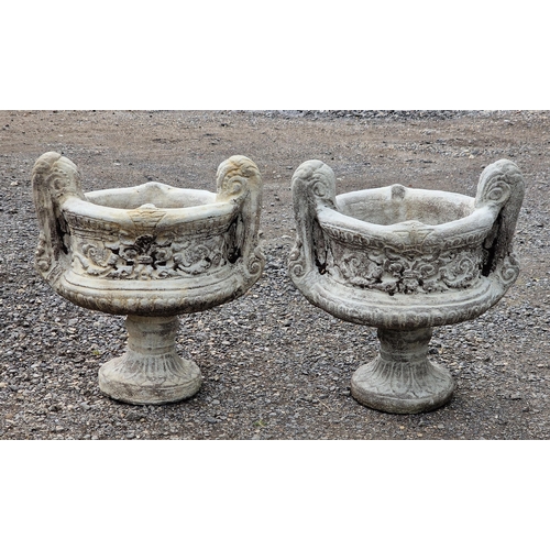 1086 - A pair of reconstituted stone two sectional trophy shaped garden urns with scrolled foliate relief d... 