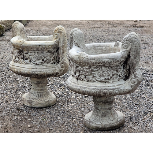 1086 - A pair of reconstituted stone two sectional trophy shaped garden urns with scrolled foliate relief d... 