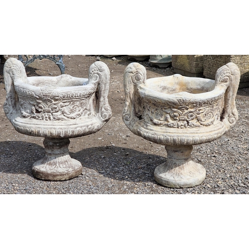 1086 - A pair of reconstituted stone two sectional trophy shaped garden urns with scrolled foliate relief d... 