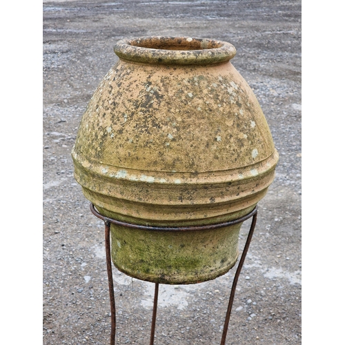 1101 - Weathered terracotta urn with banded detail raised on an associated scrolled metal stand, H 46cm (ur... 