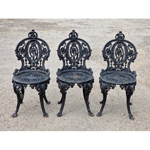 1214 - Three Victorian painted cast iron garden chairs with scrolling pierced detail, raised on swept suppo... 