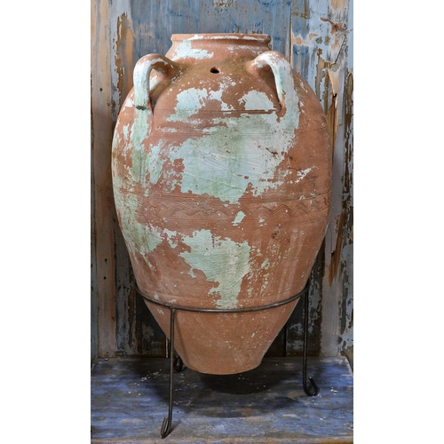 1249 - Terracotta amphora urn with twin loop handles and incised string decoration, raised on a bespoke iro... 