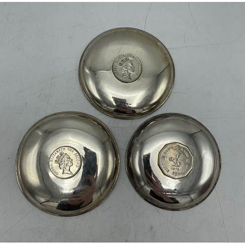 160 - Three Hong Kong silver pin dishes each fitted with a coin, 9.25cm diameter, 5oz approx (3)