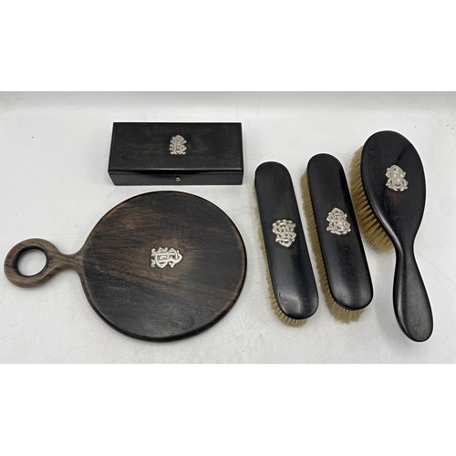 162 - Unusual exotic hardwood dressing set with silver monogram mounts, three brushes, hand mirror and lid... 