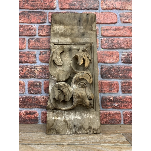 2194 - Early hand carved architectural wooden fragment with unusual scrolled face design, H 63cm x W 25cm