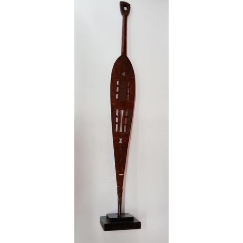 2140 - Vintage African hand carved wooden ceremonial paddle, displayed on heavy black Metal stand, H114cm