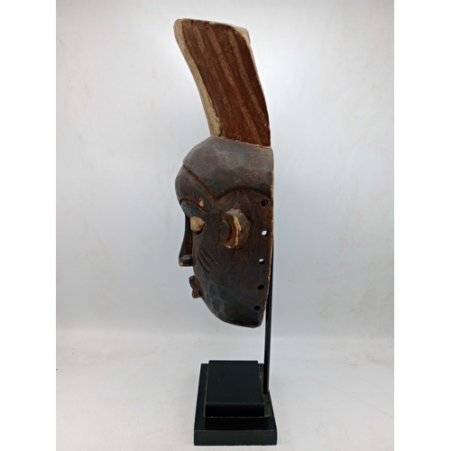 2142 - Vintage African Gabon Hand carved wooden Mask, displayed on heavy black Metal stand, H54cm